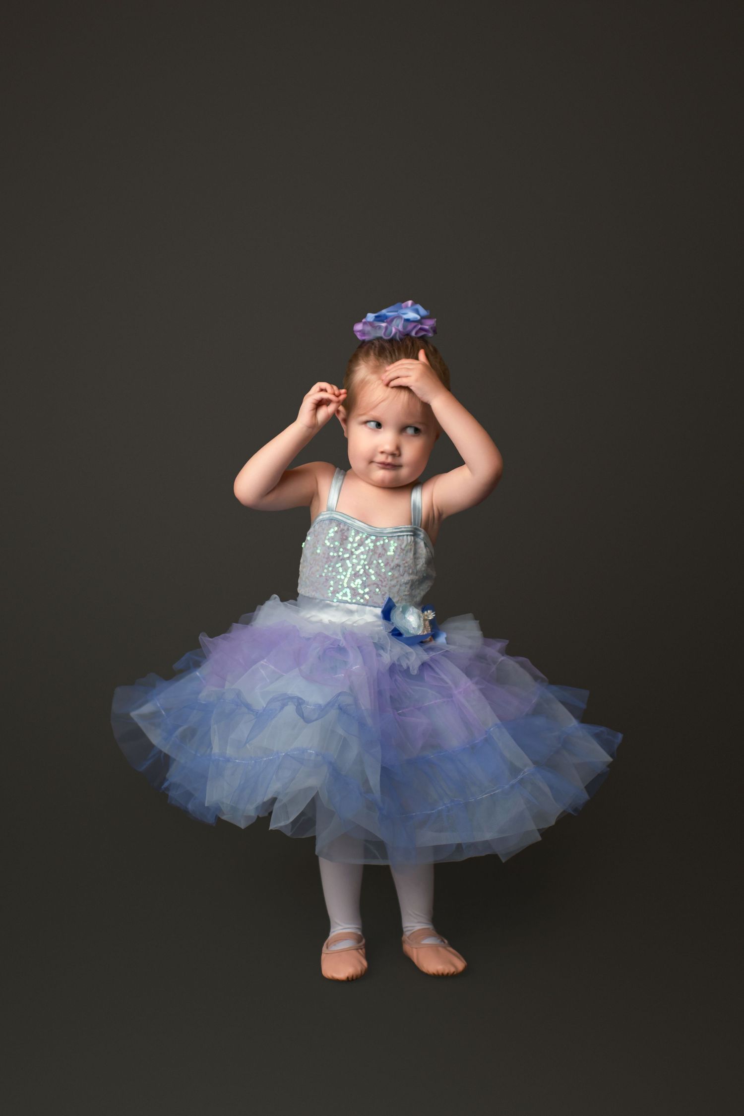 Dancer in sparkly blue tutu twirls during studio performance session.
