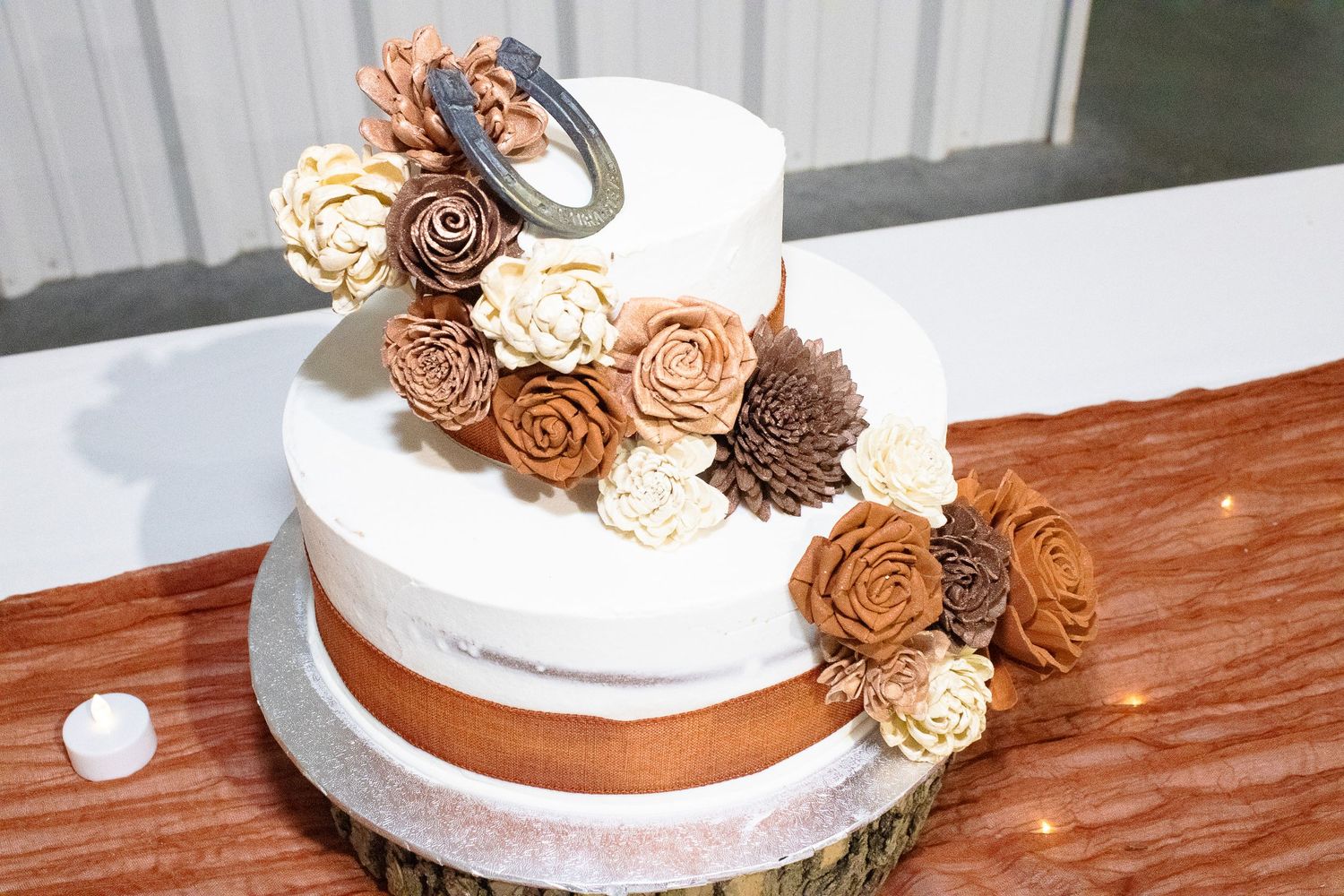 Wedding cake decorated with cascading bronze and cream colored roses.