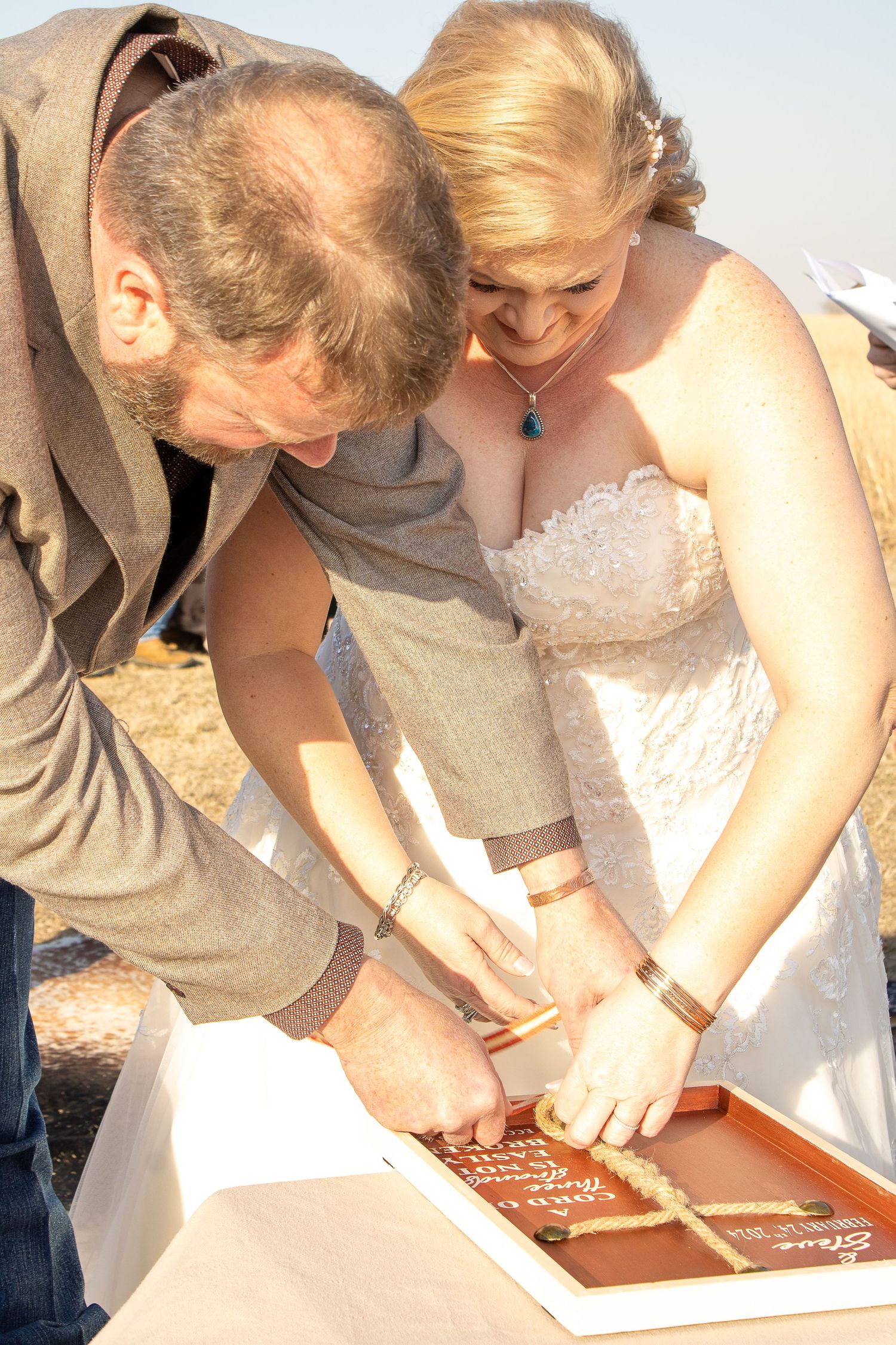 Wedding guests gathered around signing a guestbook outdoors.