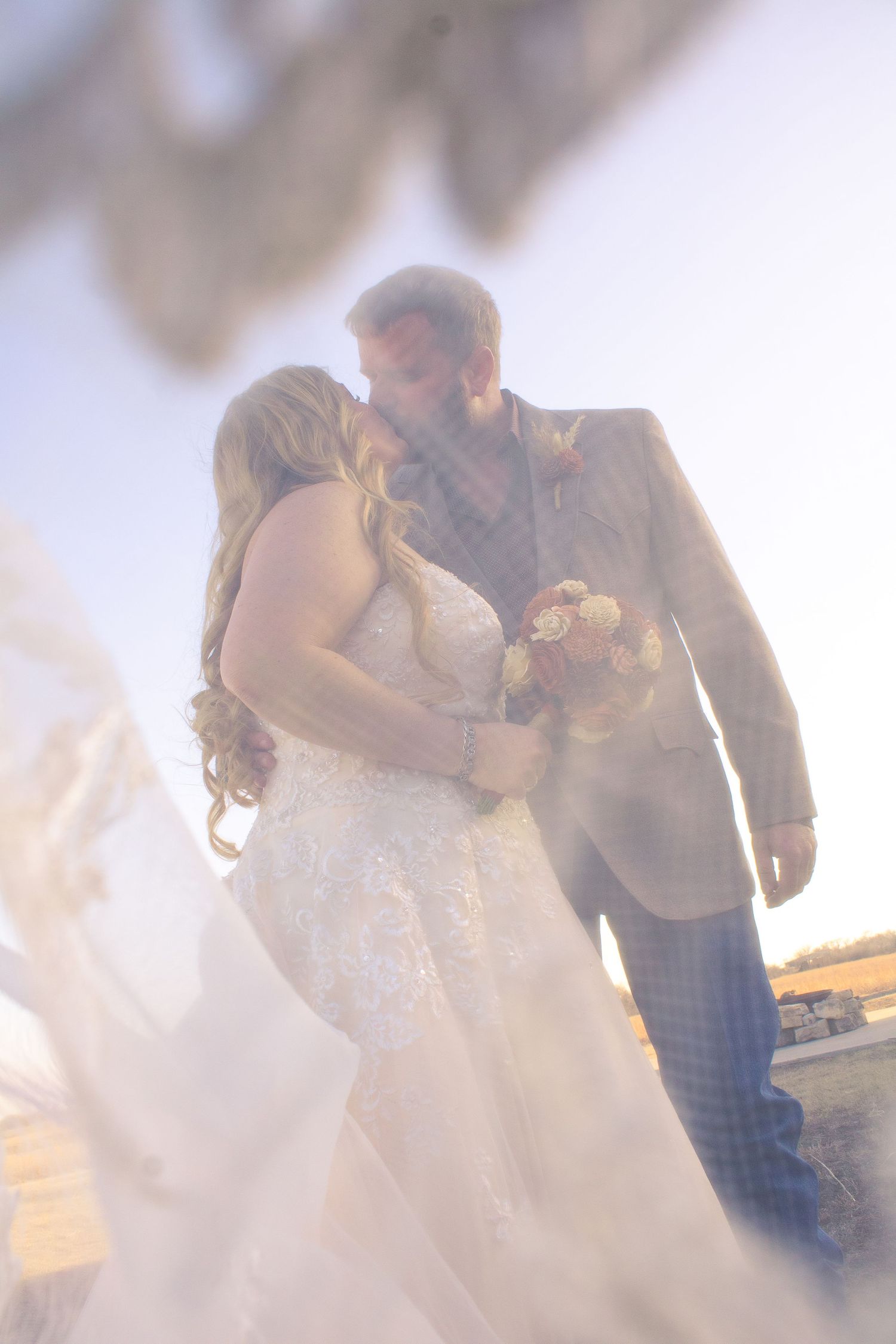 Dreamy outdoor wedding scene with soft lighting and guests.