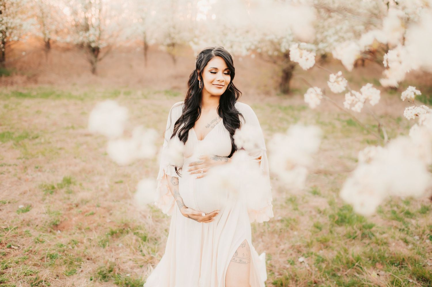 Ethereal maternity portrait with smoke effects in a dreamy outdoor setting.