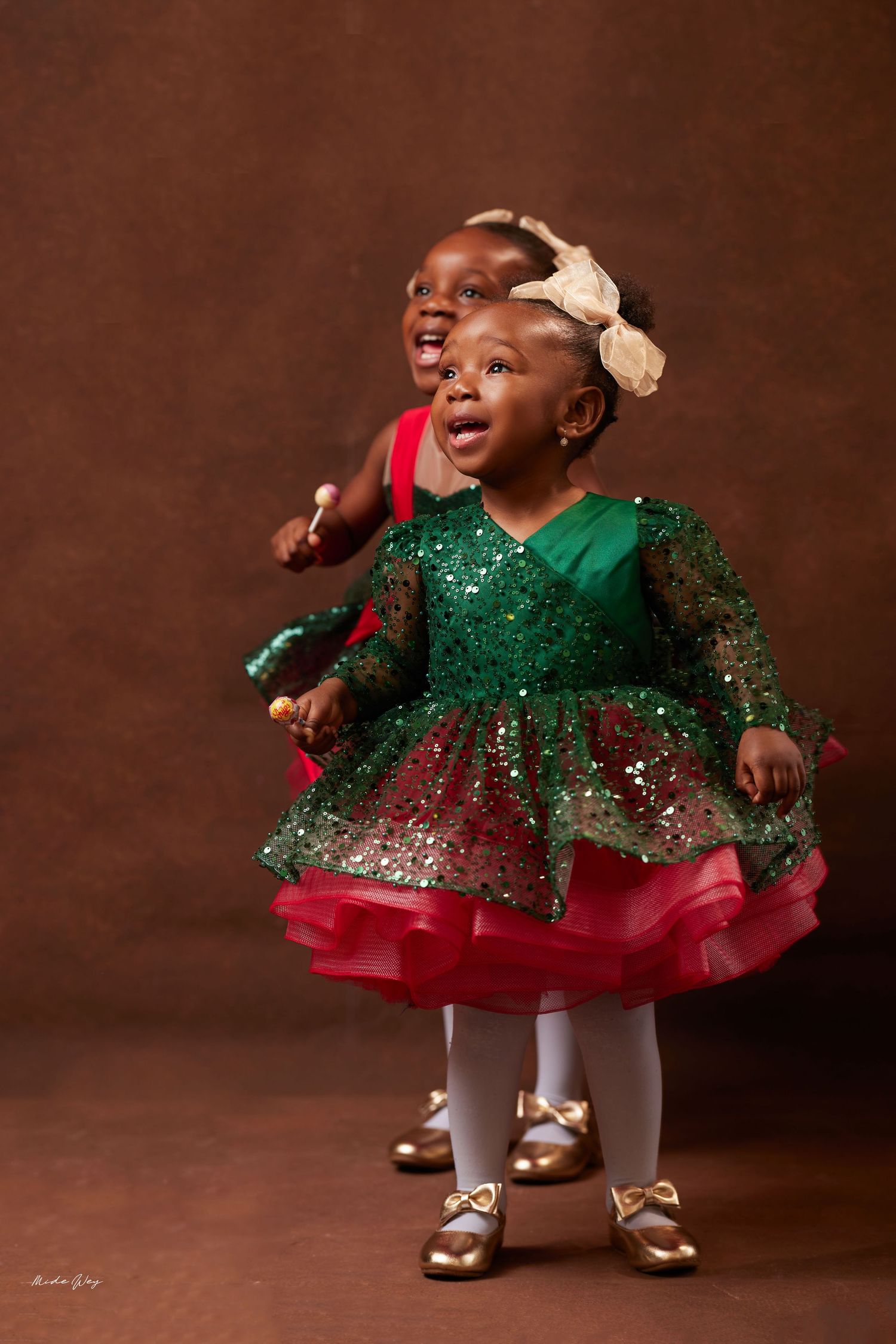 A series of photos showing a baby in a sparkly green and red holiday dress with white tights and silver shoes.