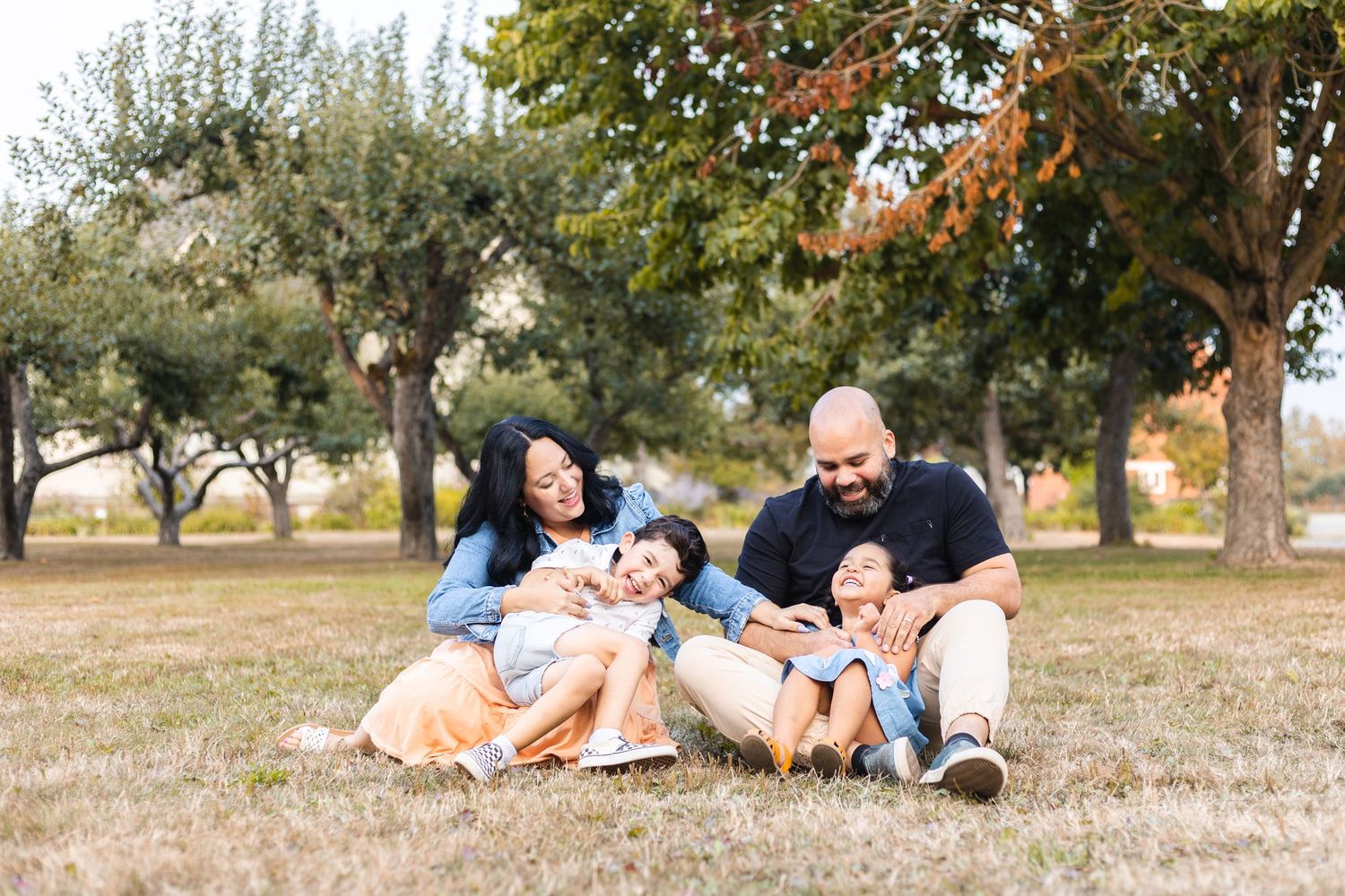 Black and white portrait of mother and children sharing an intimate outdoor moment.