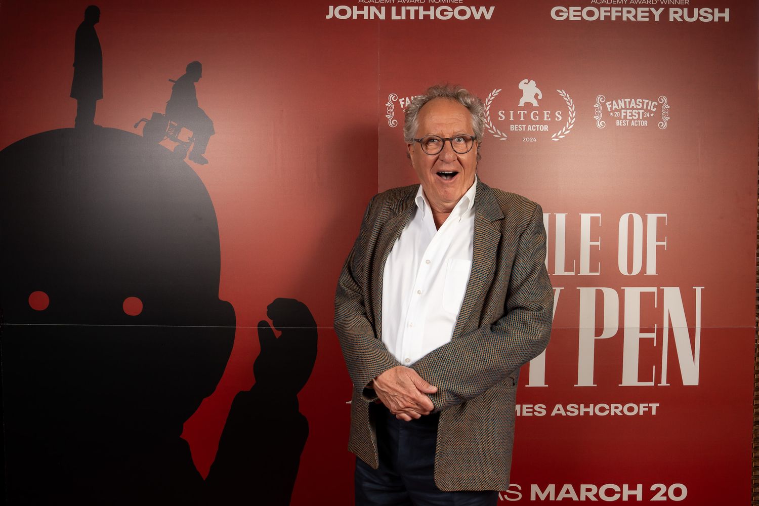 Geoffrey Rush in front of a media wall for the film The Rule of Jenny Pen