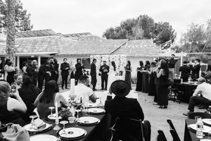 A black and white photo montage shows wedding guests mingling and celebrating at an outdoor reception venue.