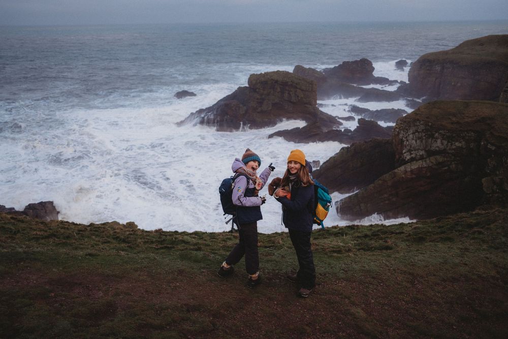 Dramatic coastal landscape with rocky cliffs and crashing waves along a rugged shoreline.