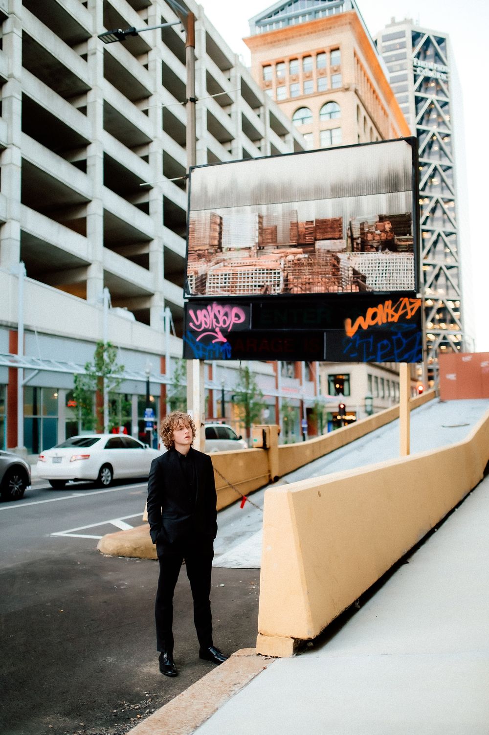 A sequence of photos showing a person walking up a ramp in an urban parking structure setting.