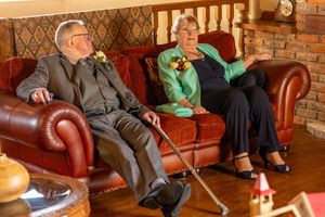 Older wedding guests sitting on a sofa inside the windmill at Windmill Farm in Burscough during the wedding day.