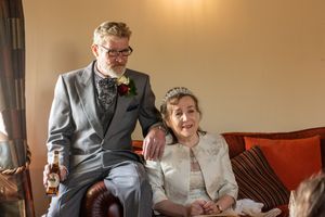 Bride and groom relaxing together on a leather sofa inside the windmill at Windmill Farm in Burscough after their wedding.