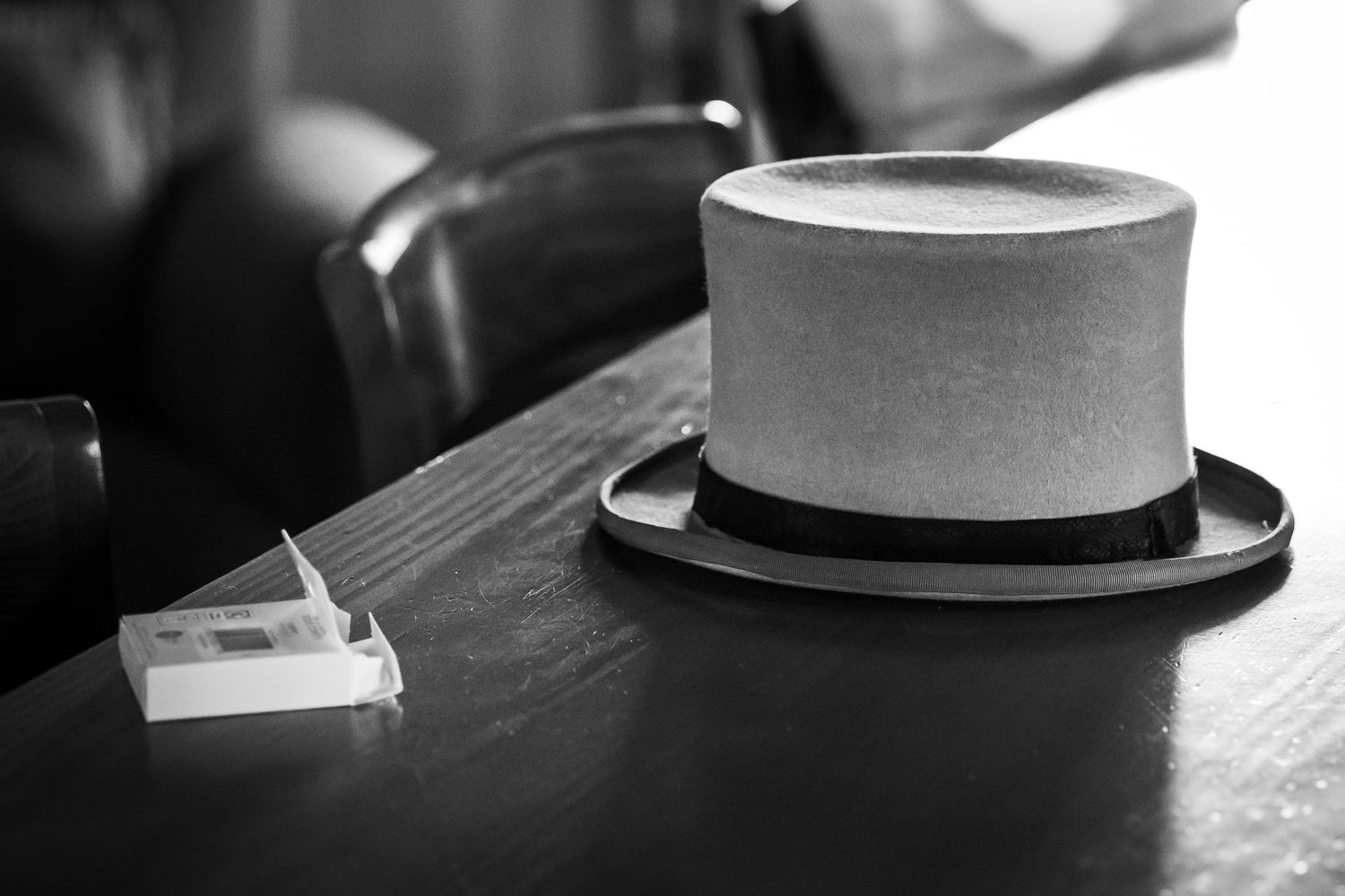 Top hat resting on a table beside mints during a quiet wedding moment at Windmill Farm in Burscough.