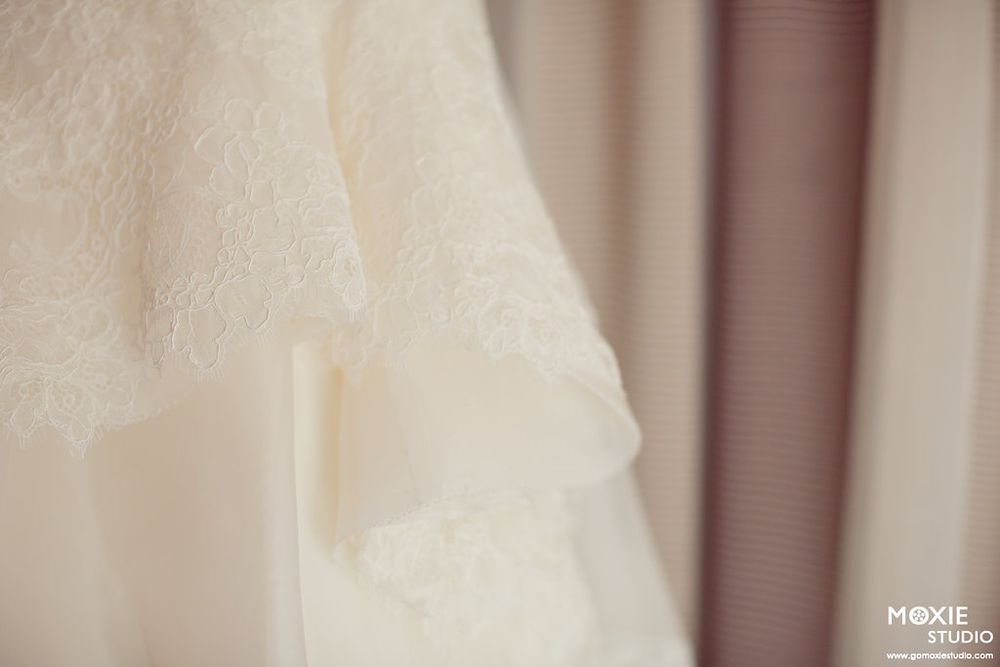 Close-up detail shot of delicate white wedding dress fabric and lace.