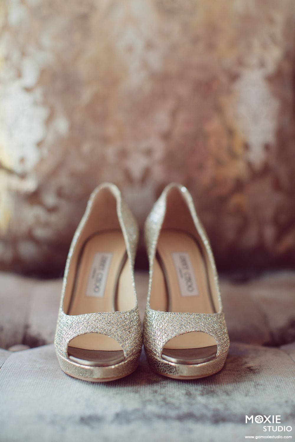 Four detailed shots of sparkly gold Jimmy Choo bridal flats displayed on textured surface.