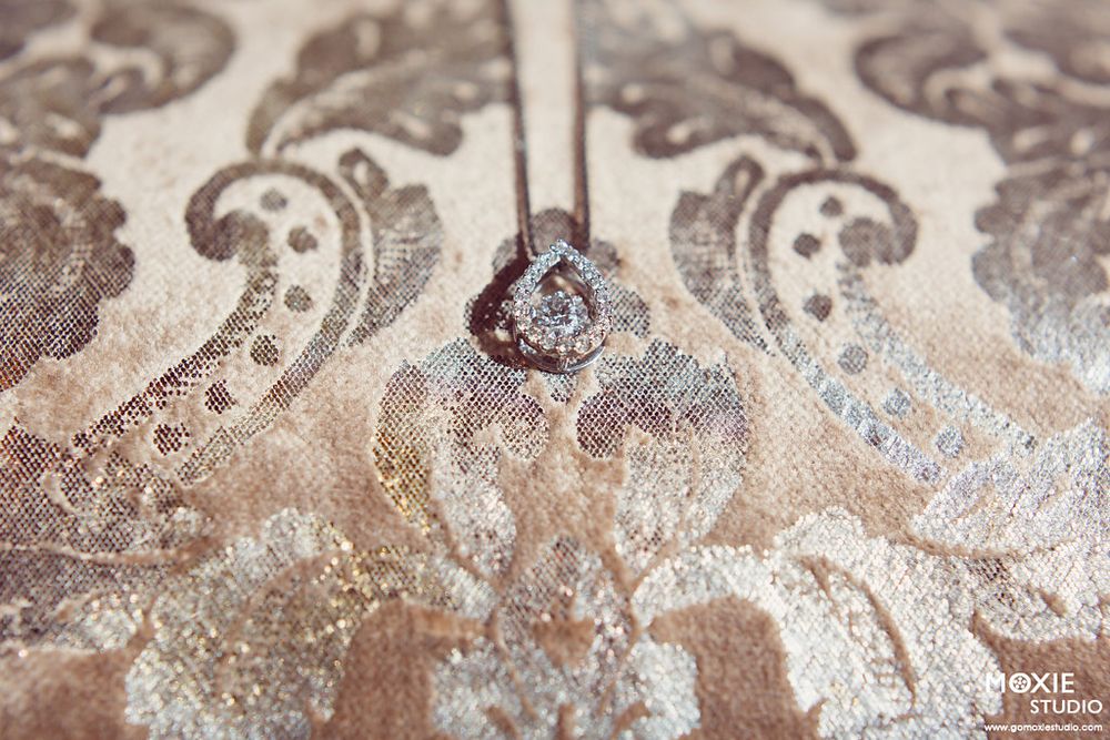 Elegant swirling silver patterns and designs on a textured surface create an abstract background.
