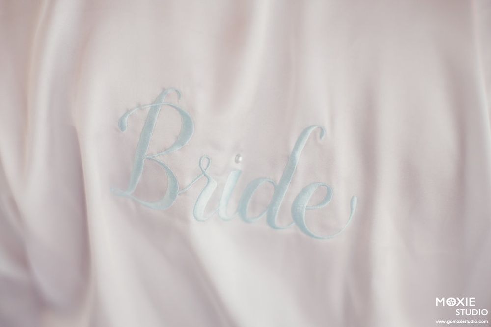 Close-up detail of delicate white fabric with subtle embroidered text.