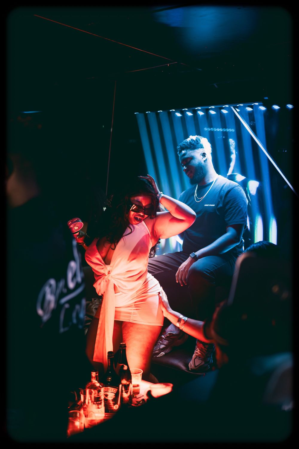 Performers on stage bathed in dramatic blue and red lighting create an atmospheric concert scene during a live music show.