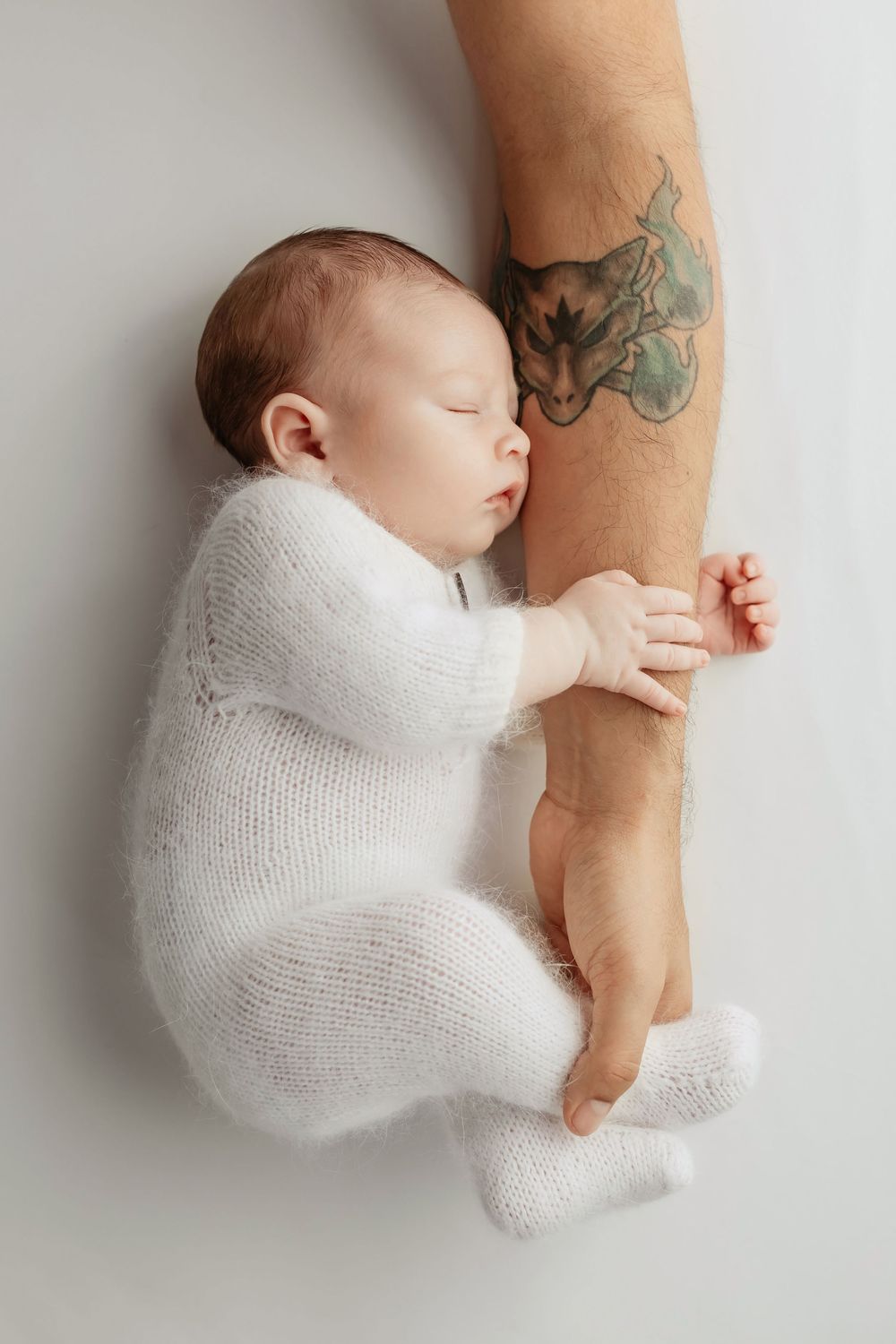 Newborn photo featuring daddy's hands with Pokémon tattoo, taken by Jen Knightstep, Photographer