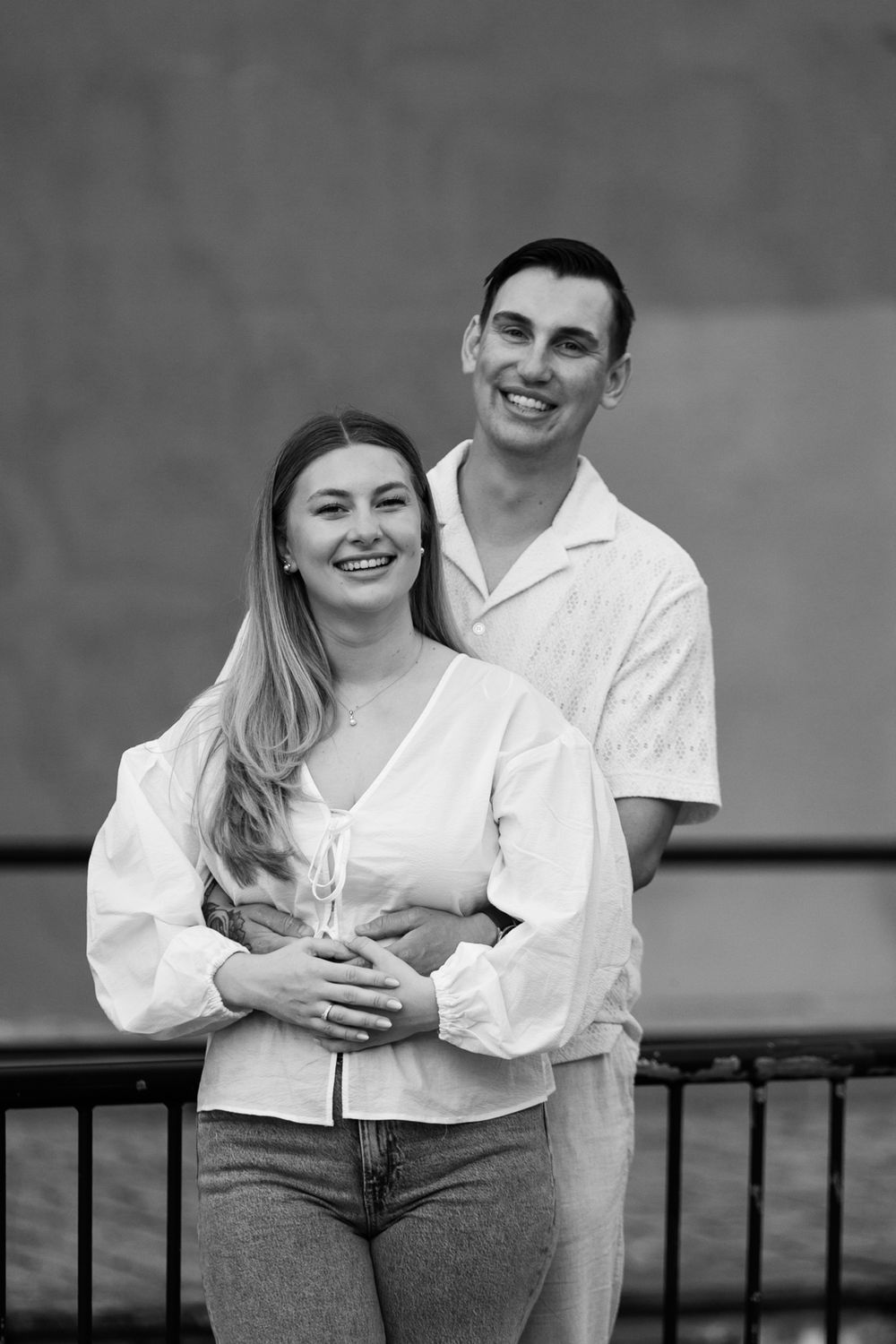 A black and white series of romantic couple portraits showing tender moments against a brick wall background.