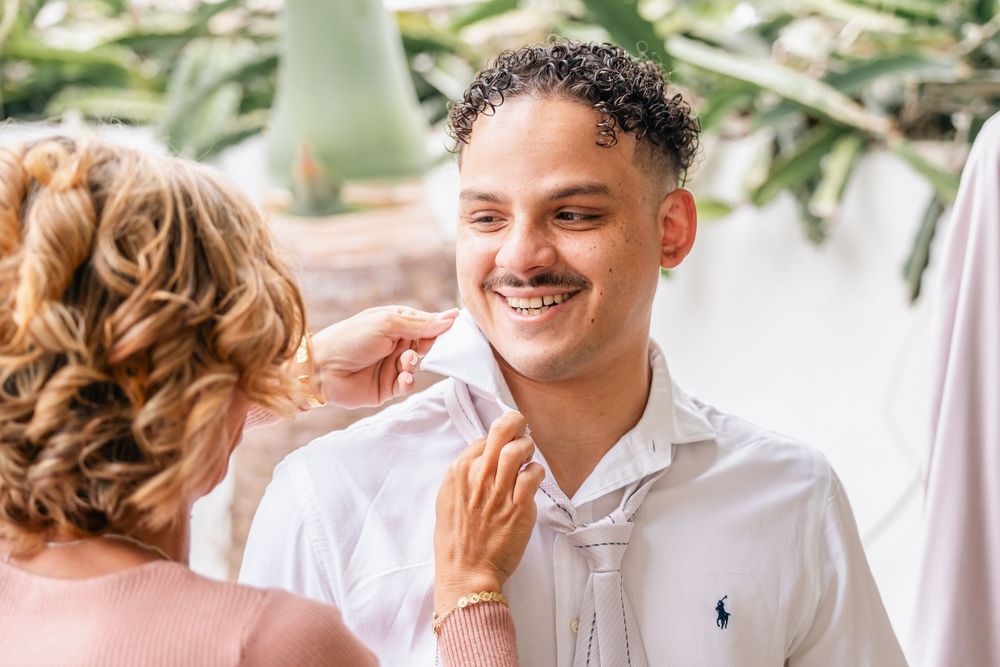 A couple in white attire share joyful moments together during an outdoor photoshoot.