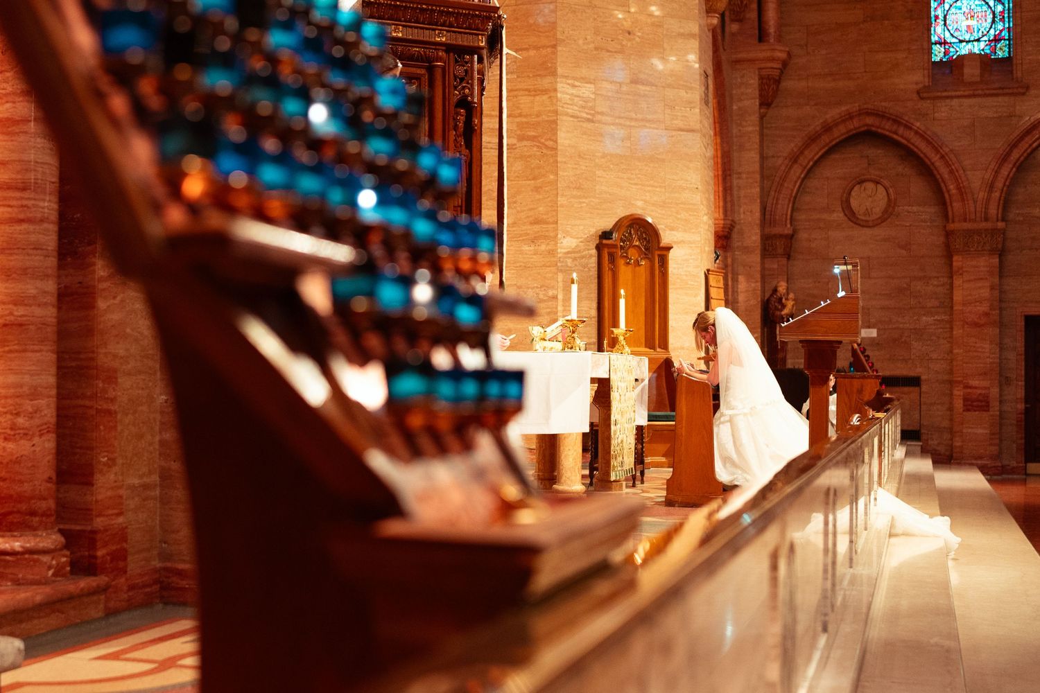 Illuminated stone church interior with arched hallways and warm lighting creates a dramatic architectural atmosphere.