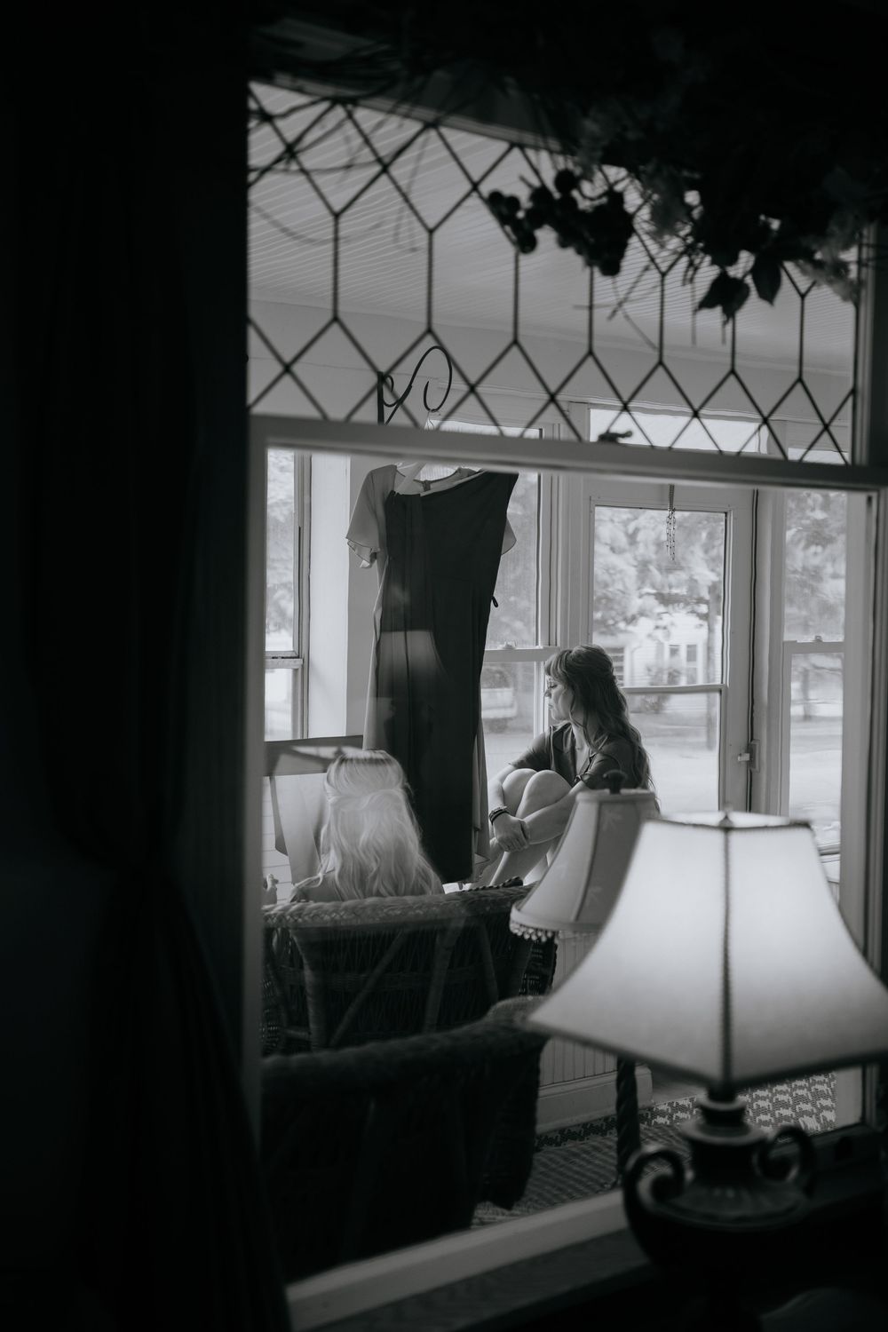 Black and white photo of a vintage window with decorative lattice pattern.
