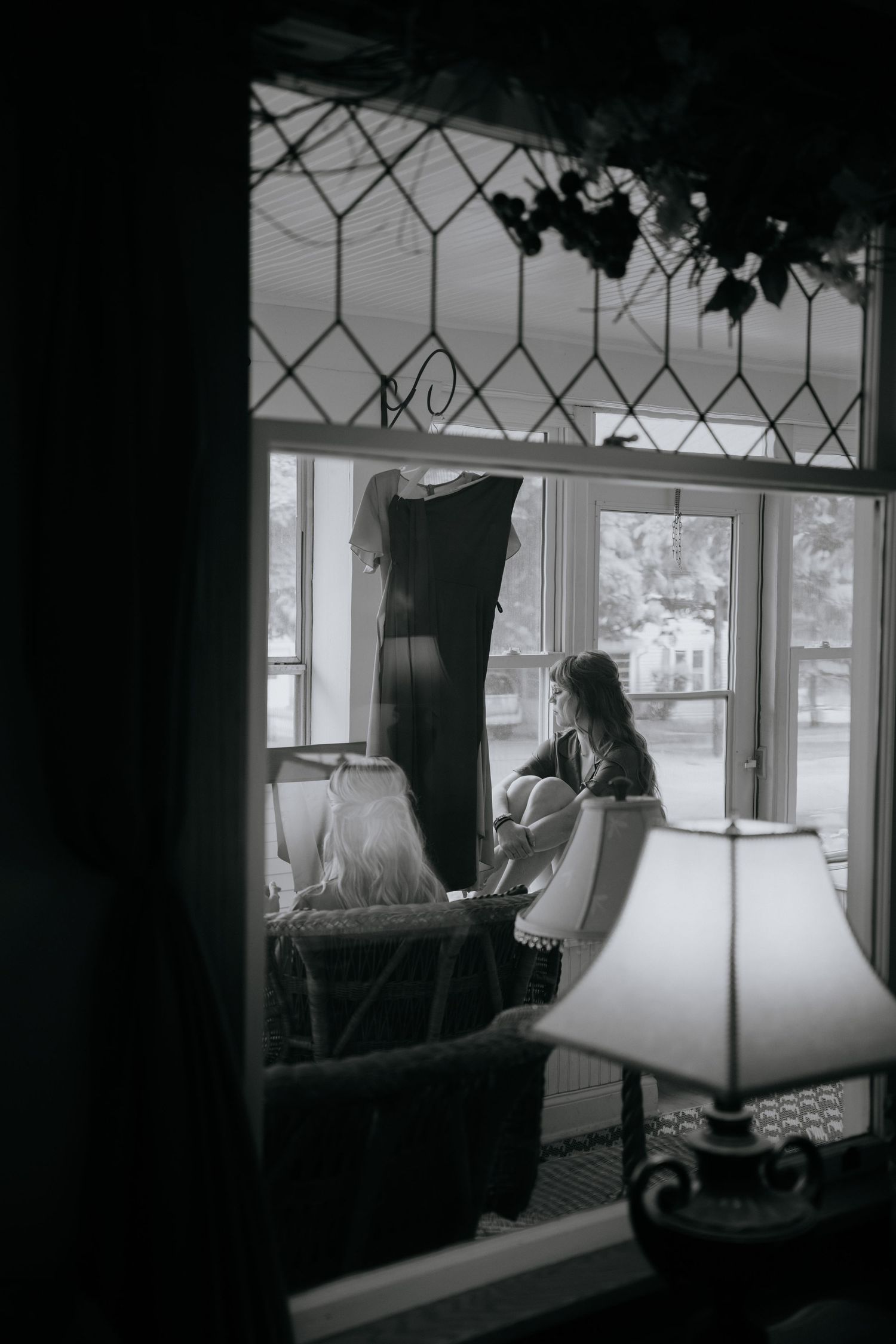 Black and white photo of a vintage window with decorative lattice pattern.
