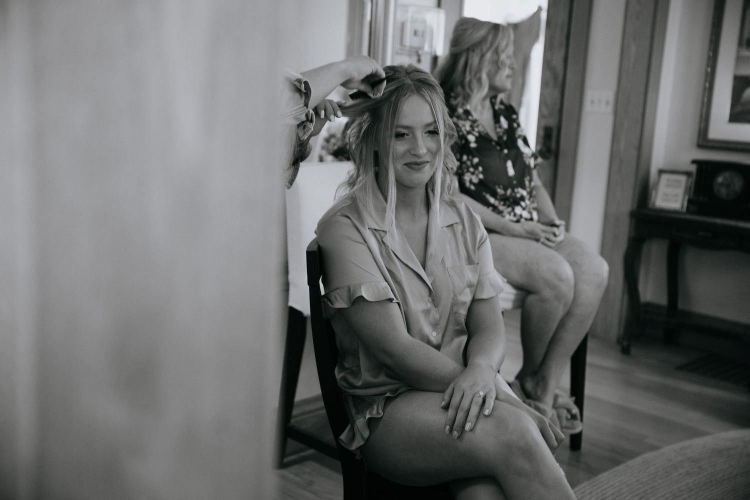 Black and white candid moments of wedding preparation in an indoor setting.
