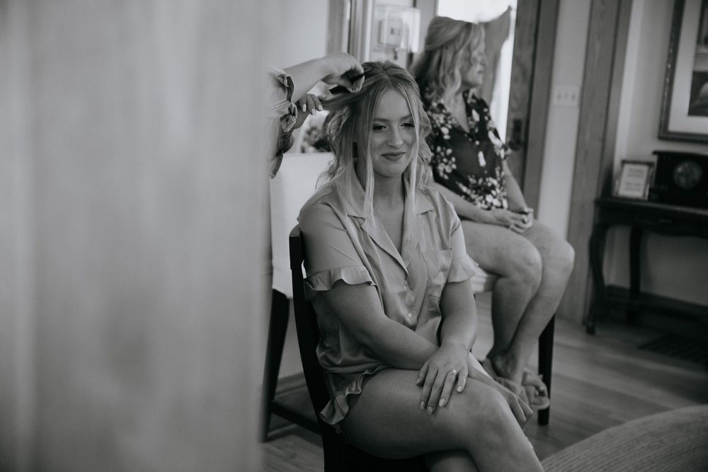Black and white candid moments of wedding preparation in an indoor setting.