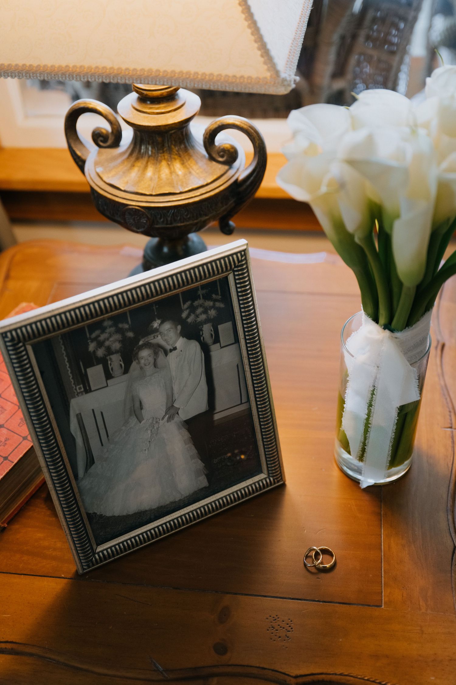 Vintage-style framed photographs displayed on wooden table with white tulips and decorative elements.