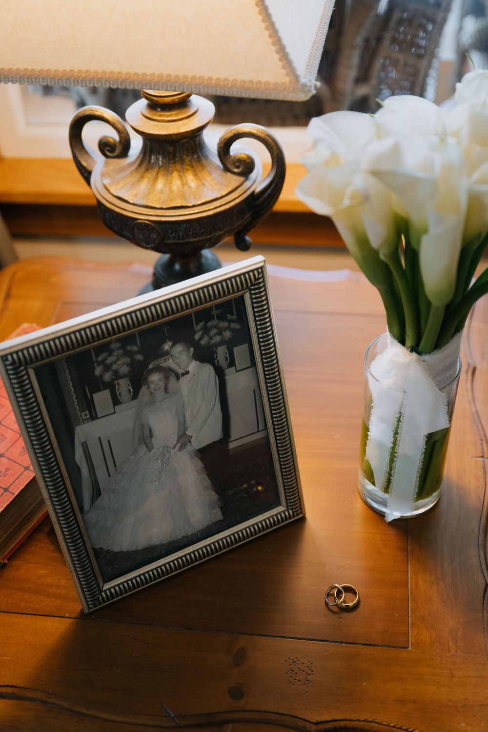 Vintage-style framed photographs displayed on wooden table with white tulips and decorative elements.