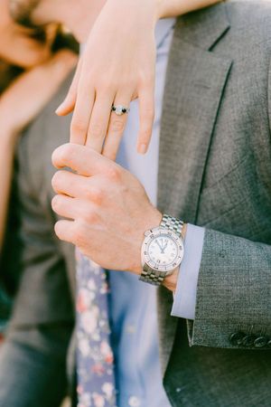 Close-up shots of hands wearing wedding rings and formal attire in a series of detail photographs.