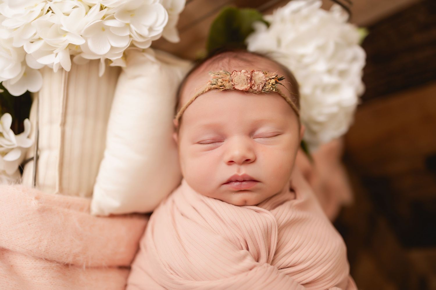 Newborn photography setup with soft blankets and delicate baby posing details