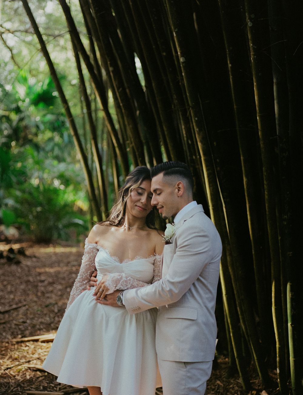A romantic couple embraces in a bamboo forest setting during their wedding photo session.