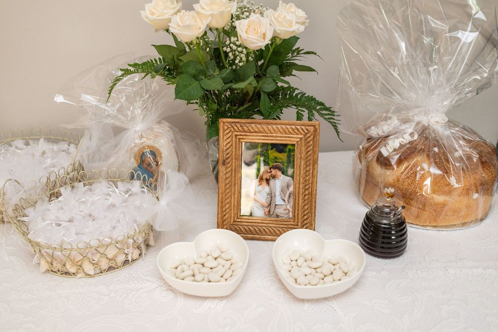 White roses and delicate wrapped gift baskets arranged in an elegant display on a light surface.