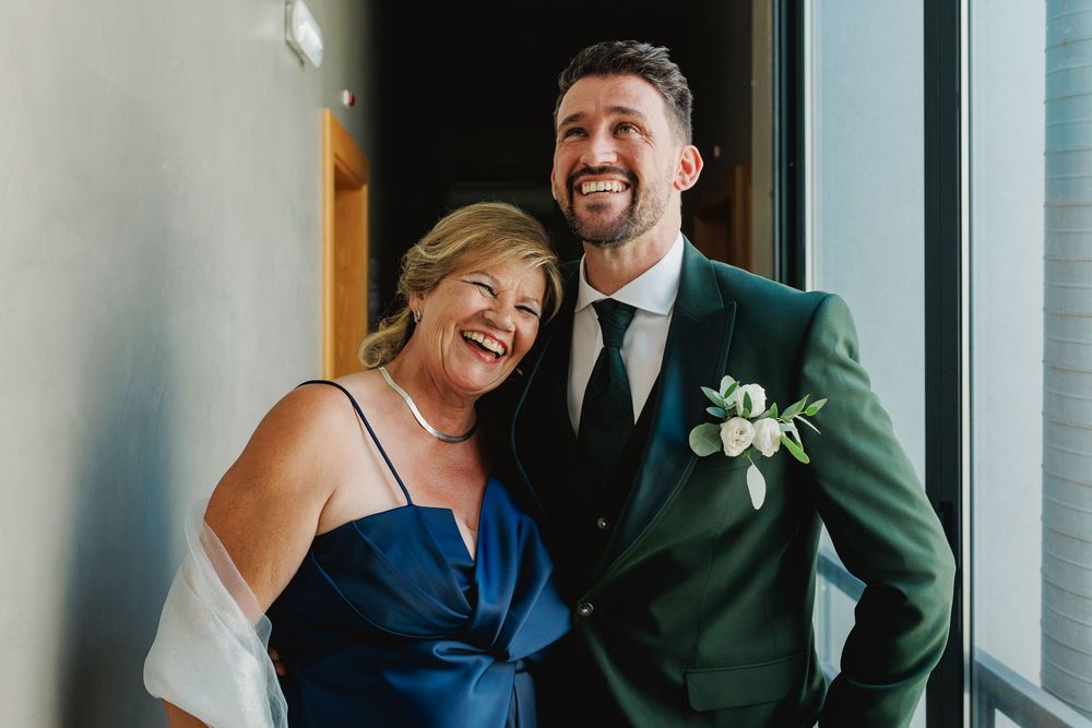 groom laughing with his mother during wedding morning preparations