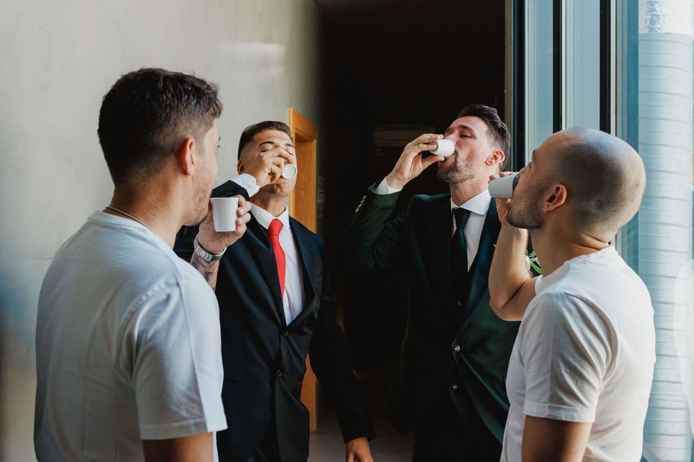 groom and friends doing a celebratory shot during wedding preparations