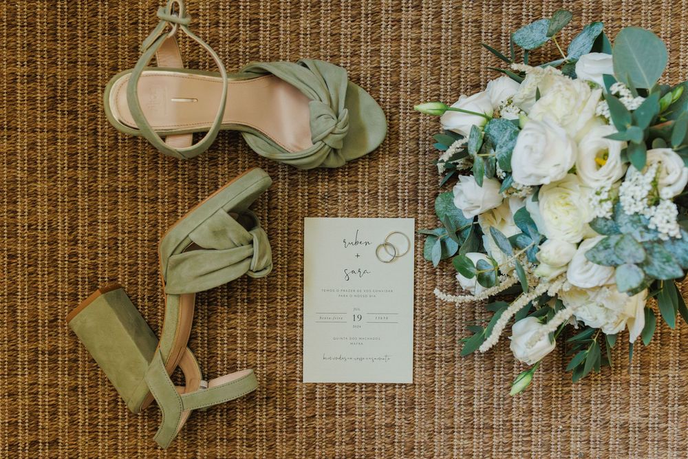 bridal details with bouquet shoes and wedding invitation flat lay