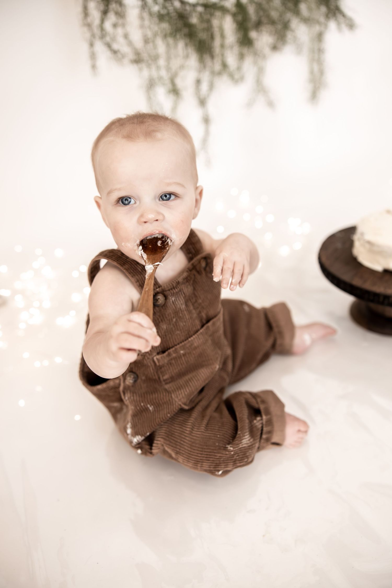 Studion cake smash session for first birthday, showing a little boy tasting cake in Central Indiana.