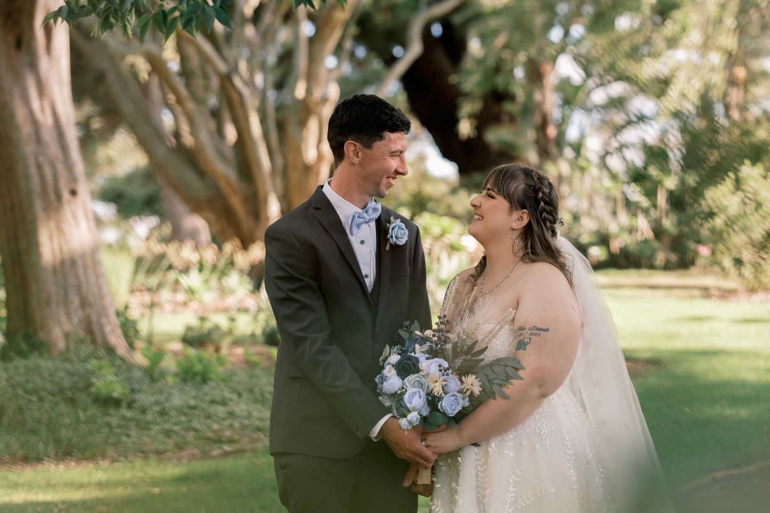 Elegant wedding couple poses in and around vintage cars during their special day.