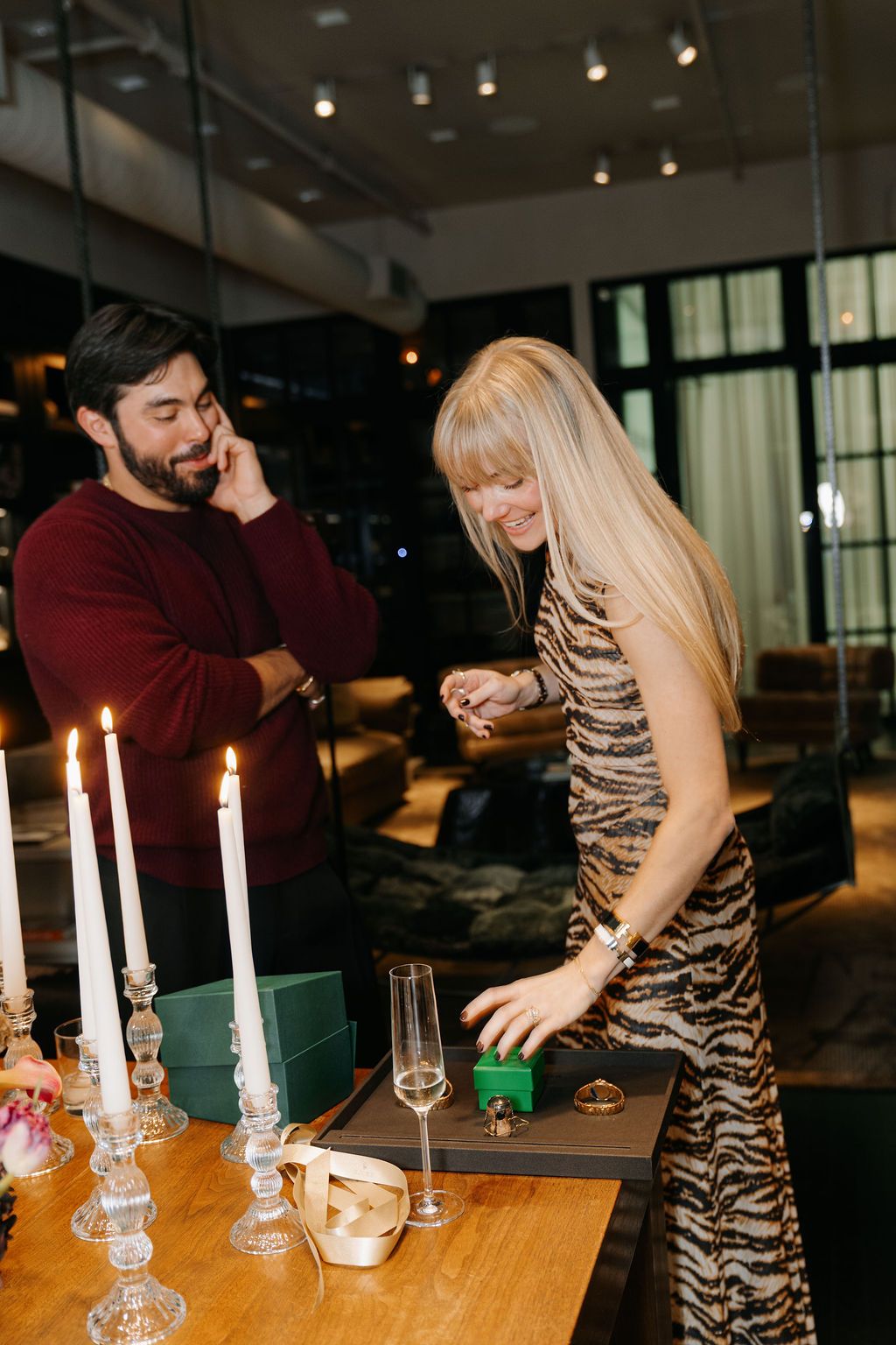 A couple celebrates at a romantic candlelit table with wine glasses in an elegant restaurant setting.