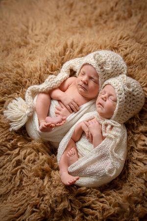 twin girl newborn session with boho setup brown flokati and handmade outfits