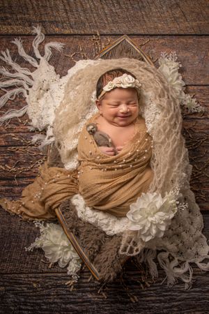 newborn session sleeping baby smiling neutral props with white flowers
