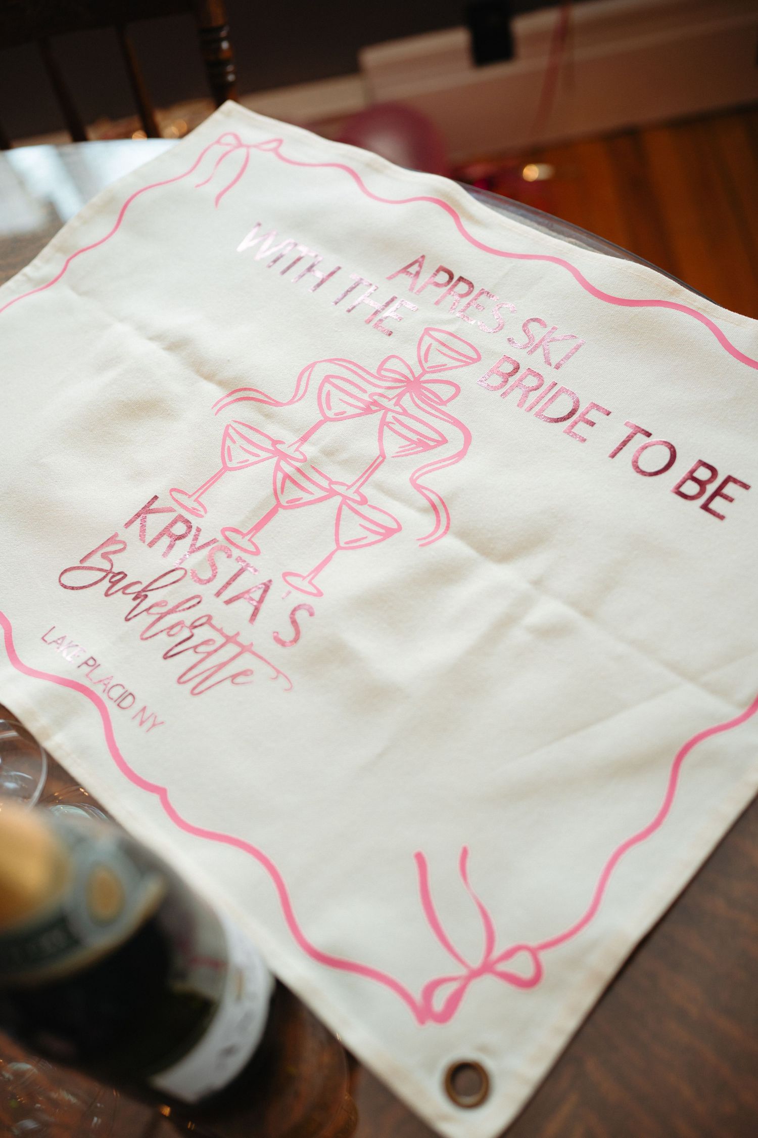 Pink text written on white napkins arranged in a row on a wooden surface.