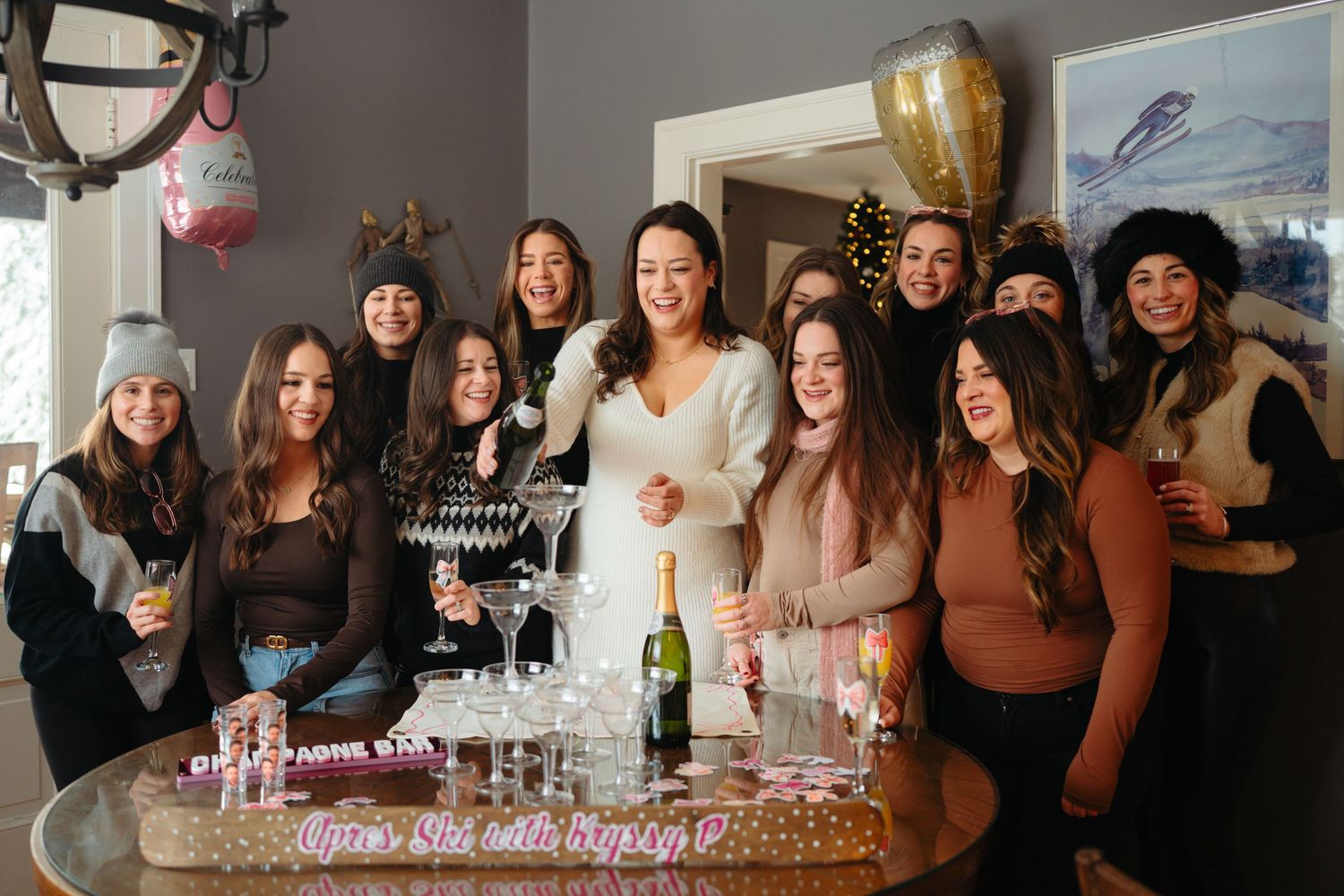 A group of people gather around a long table with champagne glasses celebrating a festive occasion together.