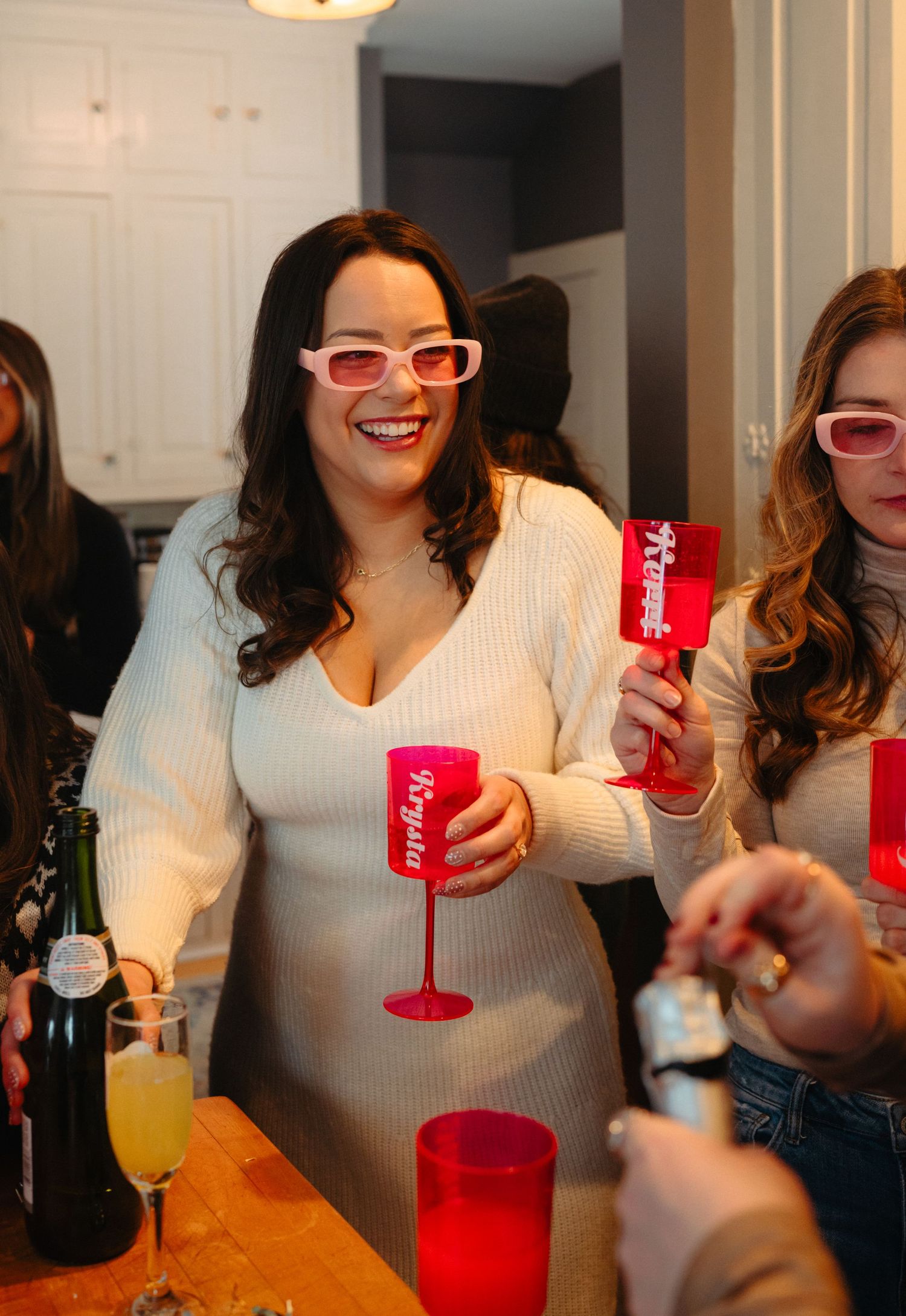 A winter celebration with partygoers holding red drinks and wearing festive attire.