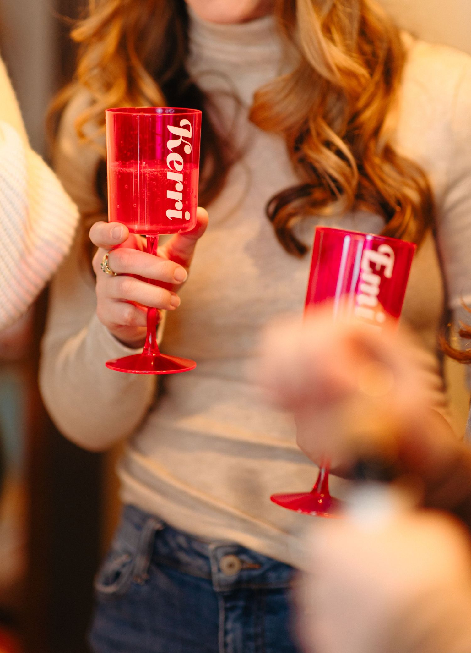 Red wine glasses being held in a sequence of close-up shots against a light-colored background.