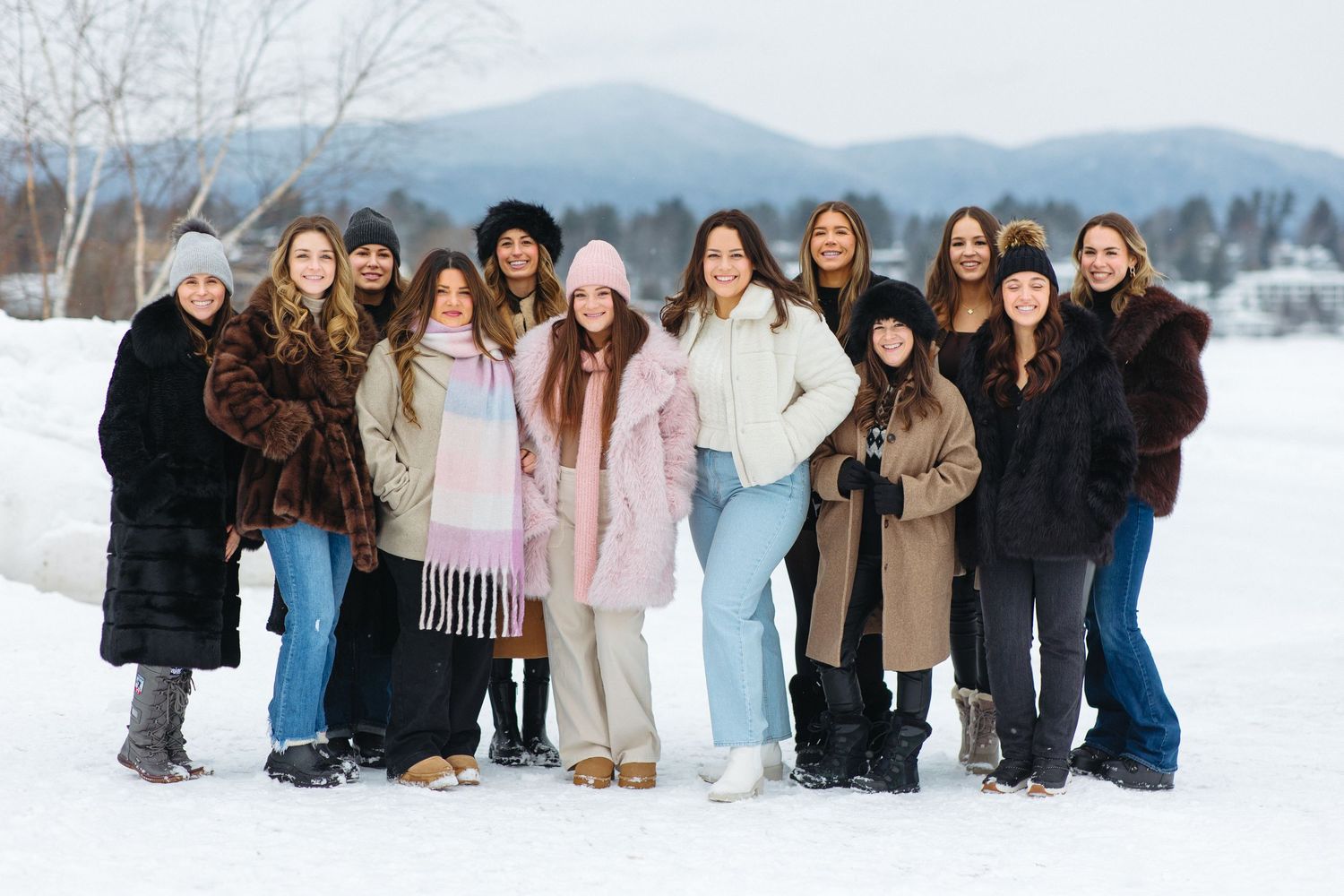 Large group photo of people posing together in snowy winter landscape.