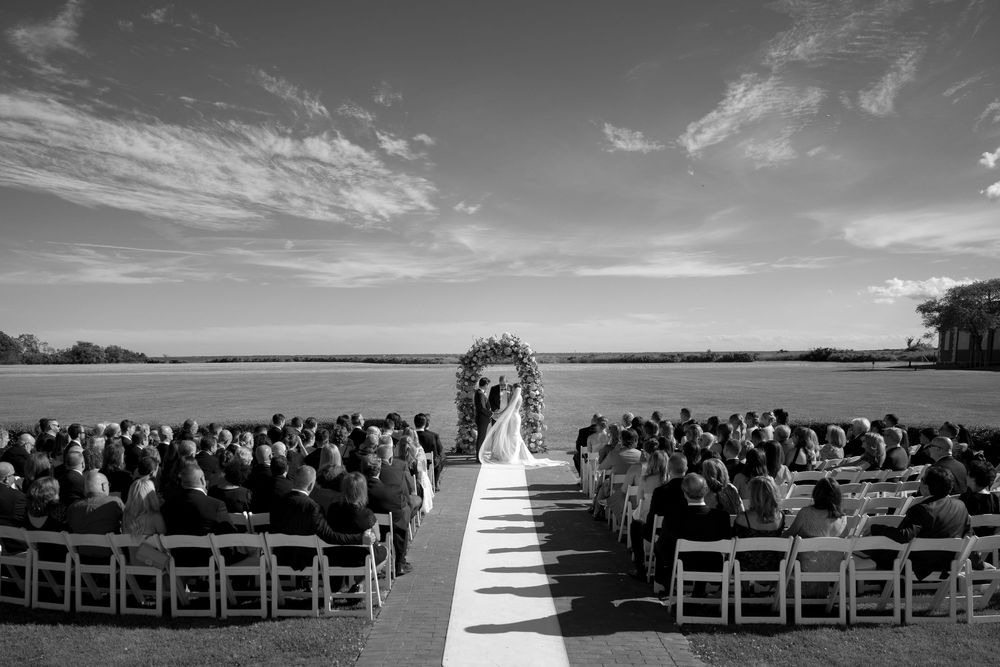 A black and white panoramic collage of an outdoor beach wedding ceremony with chairs arranged facing the ocean.