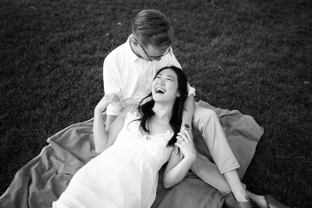 A series of black and white photos showing a person lying on grass in various relaxed poses.
