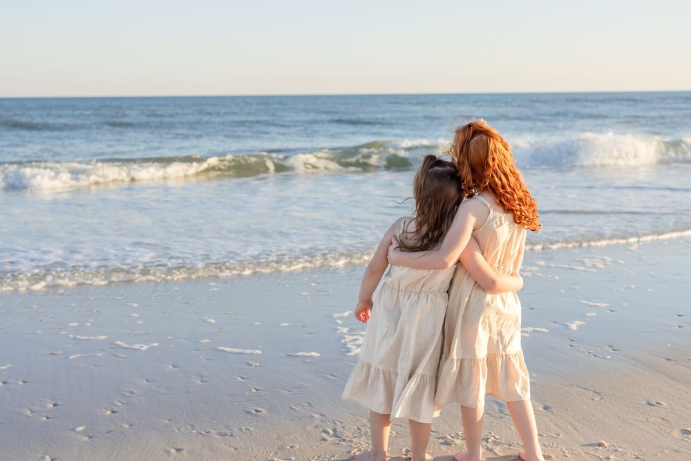 A series of photos showing a child in a white dress playing and walking along a sandy beach at sunset.