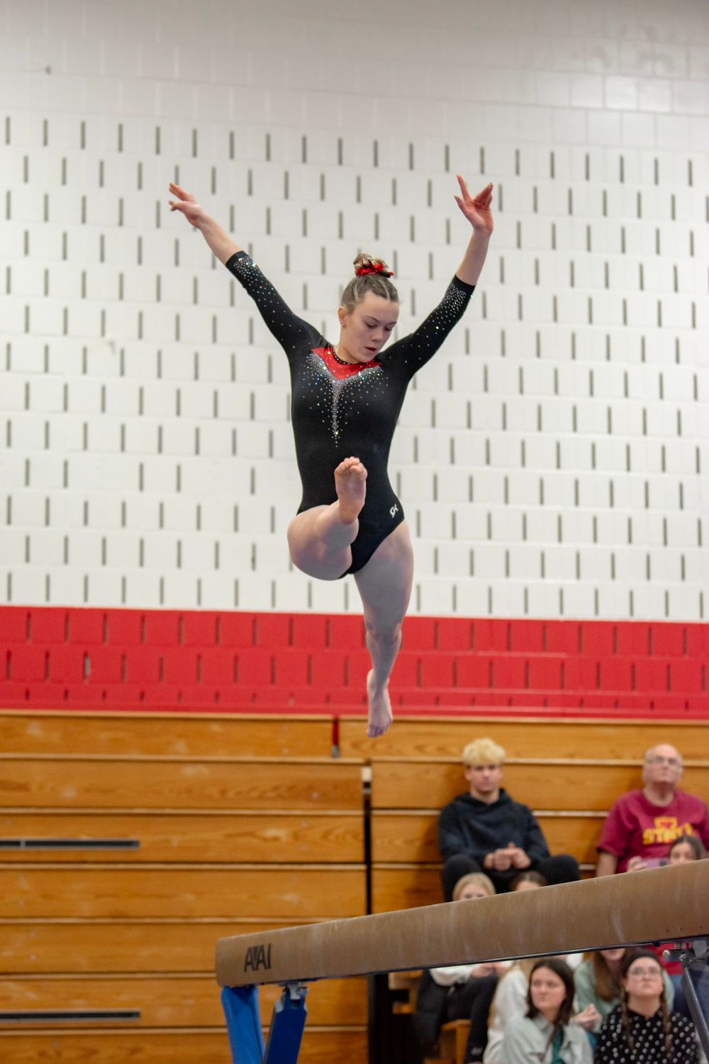 Gymnast performing a balance beam routine with precision and grace.